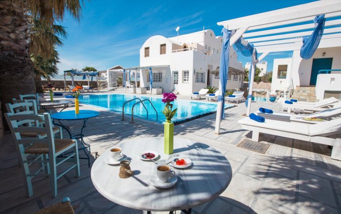 Het terras bij het zwembad van Hotel Iliada Santorini