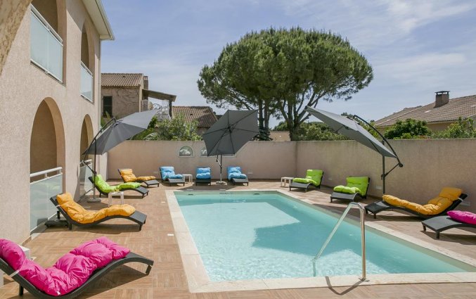Buitenzwembad en ligbedden bij Hotel U Ricordu op Corsica