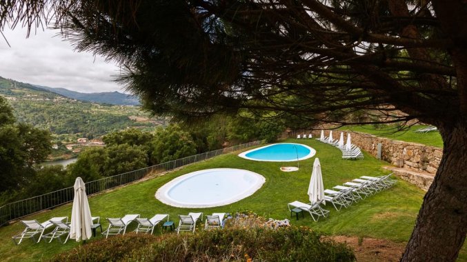 Buitenzwembad en zonneterras van Hotel Douro Palace Resort & SPA in Noord-Portugal