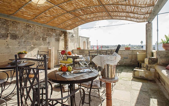 Overdekt buitenterras met stoelen en tafels van Hotel Borgoterra in Puglia