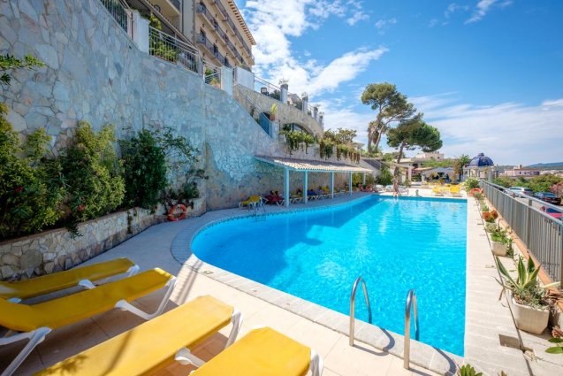 Zwembad en ligbedden van Hotel Montjoi by Brava Hoteles